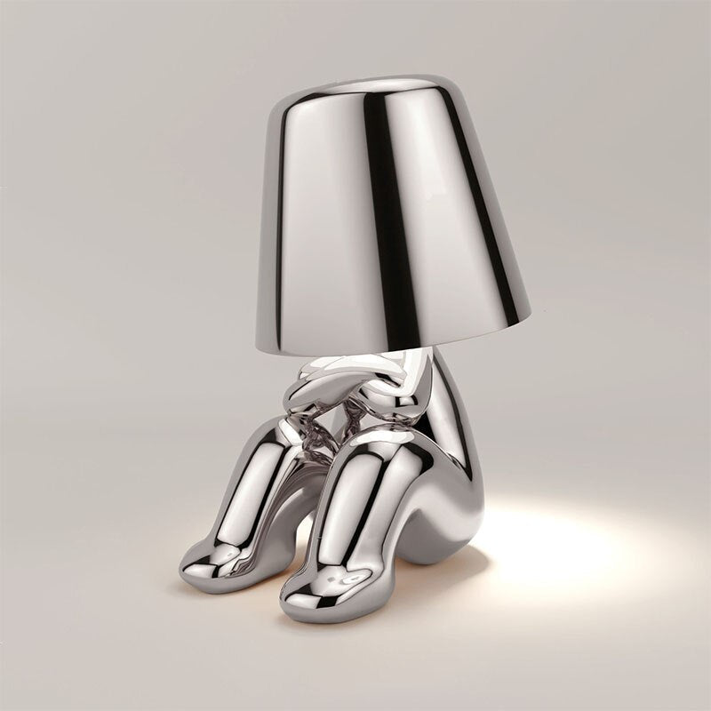 Unieke zilveren Lumineer tafellamp met een artistiek en minimalistisch design, ideaal voor flexibele en sfeervolle verlichting in moderne interieurs.