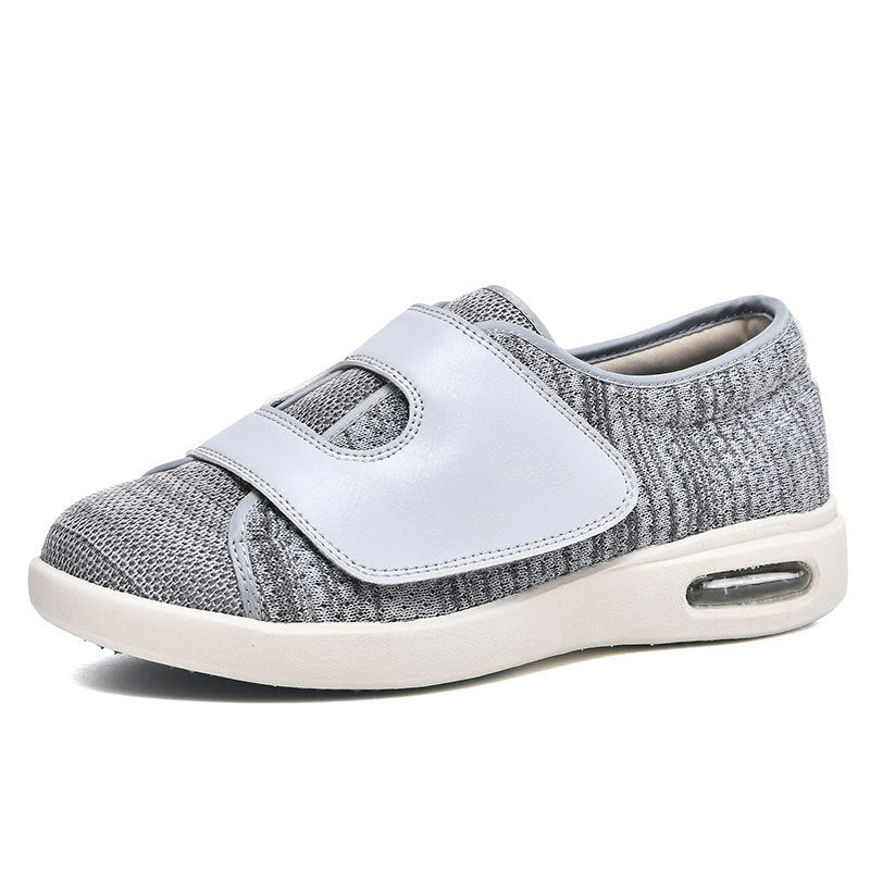 De afbeelding toont een comfortabele grijze schoen van Ondro, ontworpen met een brede pasvorm voor extra comfort. De schoen heeft een ademende bovenkant van stof en een klittenbandsluiting voor eenvoudige en snelle verstelling. De zool is uitgerust met luchtkussens voor demping, wat zorgt voor langdurig draagcomfort. Deze schoen is ideaal voor dagelijks gebruik.