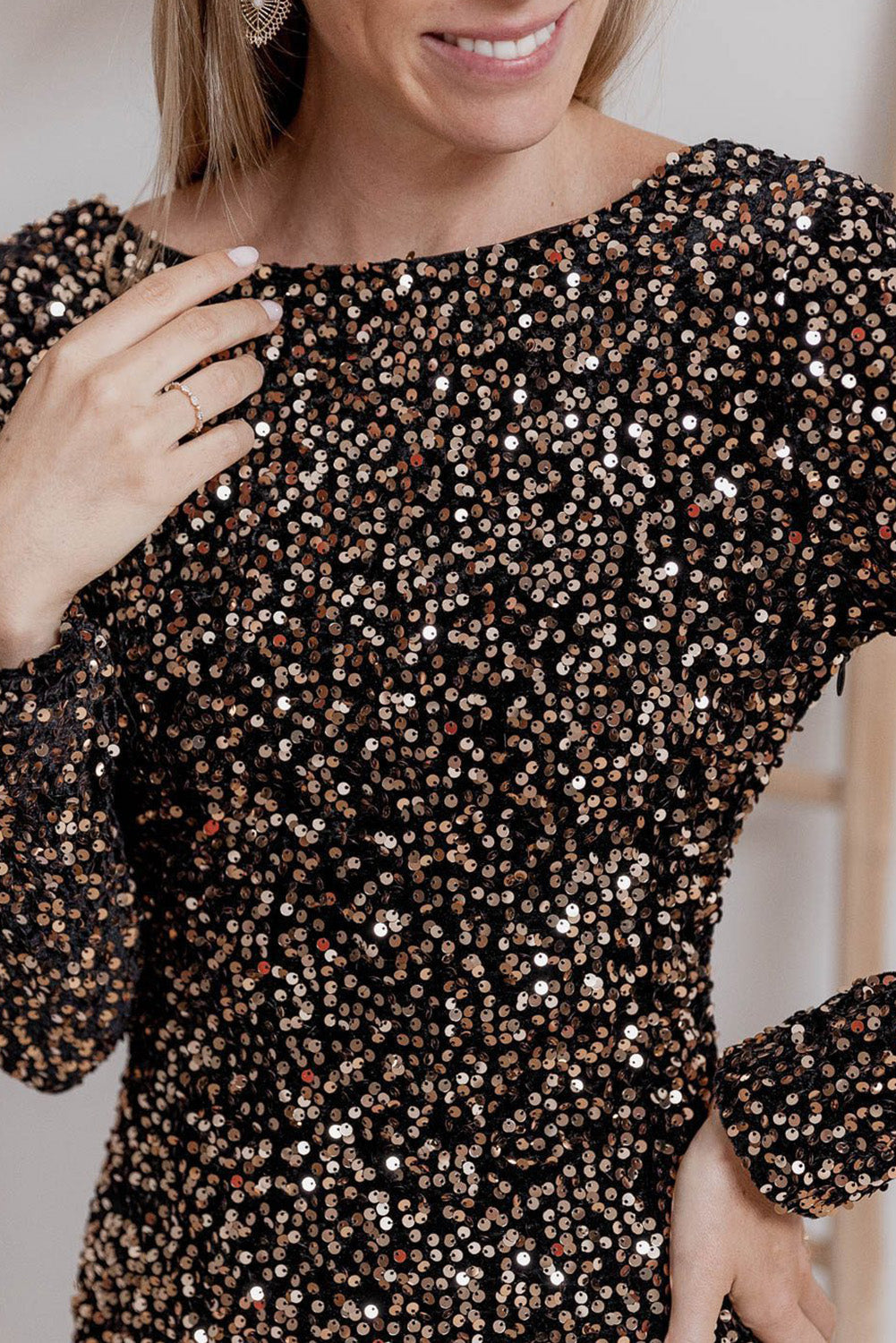 De prachtige feestjurk is bedekt met een glinsterende paillettenstof, die het ontwerp een luxe uitstraling geeft. De gouden en zilveren pailletten vangen het licht en zorgen voor een sprankelend effect, perfect voor een elegante avond. De jurk heeft een verfijnde uitstraling en een flatterende pasvorm die het figuur benadrukt.