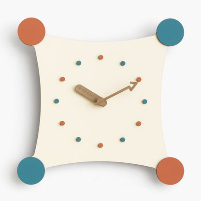 Een moderne wandklok met een speels design. De klok heeft een vierkante vorm met afgeronde hoeken, en is voorzien van kleurrijke stippen in verschillende tinten oranje, groen en blauw als urenmarkeringen. De houten wijzers en het minimalistische ontwerp geven de klok een eigentijdse uitstraling, perfect voor een modern interieur.