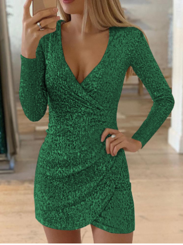Model draagt een glamour groene paillettenjurk van Zephyrine. De jurk heeft een diepe V-hals, lange mouwen en een strakke pasvorm die de vrouwelijke vormen accentueert. De glinsterende pailletten geven de jurk een luxueuze en feestelijke uitstraling, perfect voor een speciale gelegenheid.